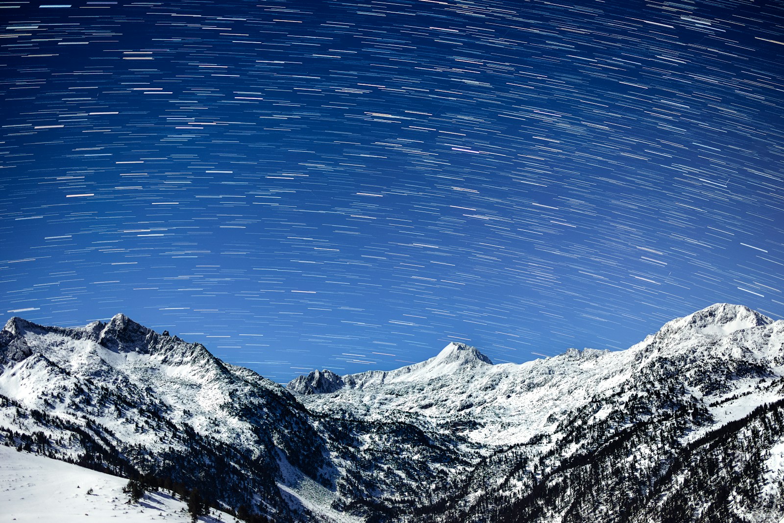 A snow covered mountain under a star filled sky